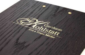 Schwarzes Menuboard mit Logoprägung auf Rückseite